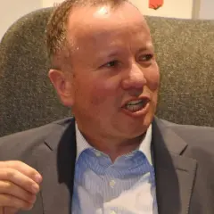 Markus Krall spricht lebhaft, vielleicht über seine Bücher. Er trägt einen Anzug und ein gestreiftes Hemd.