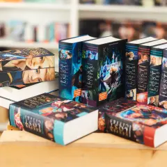 Stapel von "Keeper of the Lost Cities" Büchern, eine beliebte Fantasy-Buchreihe für Erwachsene, mit farbenfrohen Covern und Illustrationen.