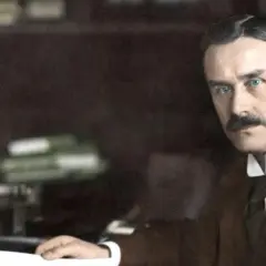Ein Mann mit Schnurrbart und blauen Augen, der an seinem Schreibtisch sitzt. Er könnte ein Vorfahre in einem stammbaum familie mann sein.