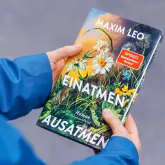 Hände halten das Buch "Einatmen Ausatmen" von SPIEGEL Bestseller-Autor Maxim Leo.