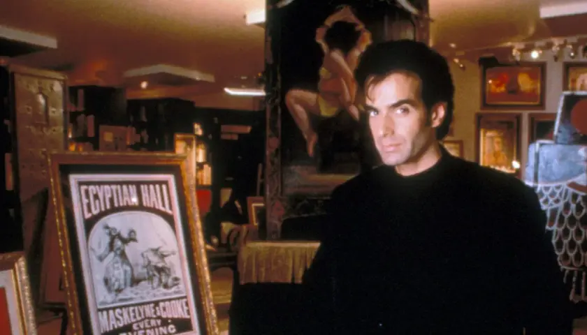 David Copperfield, umgeben von Artefakten und einem Plakat für die "Egyptian Hall", wirkt wie ein Magier, der seine Geheimnisse hütet.