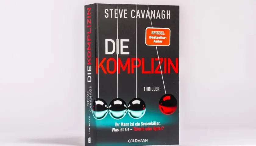 Steve Cavanaghs Thriller-Bestseller "Die Komplizin" mit einem Newtonschen Pendel. Ist ihr Mann ein Serienkiller? Täterin oder Opfer?