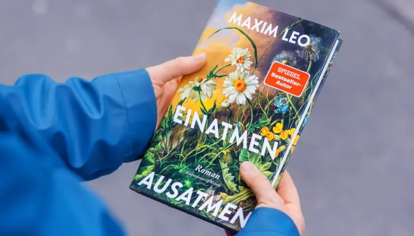 Hände halten das Buch "Einatmen Ausatmen" von SPIEGEL Bestseller-Autor Maxim Leo.
