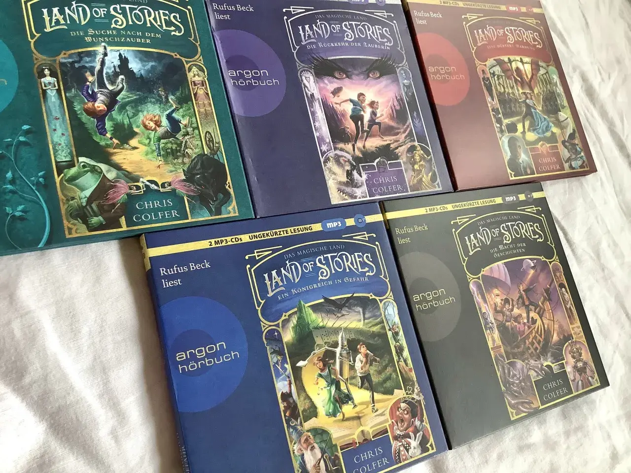 Die Hörbücher der "Land of Stories" Reihe von Chris Colfer in der richtigen land of stories reihenfolge: "Die Suche nach dem Wunschzauber", "Die Rückkehr der Zauberin", "Eine düstere Warnung", "Ein Königreich in Gefahr" und "Die Macht der Geschichten".