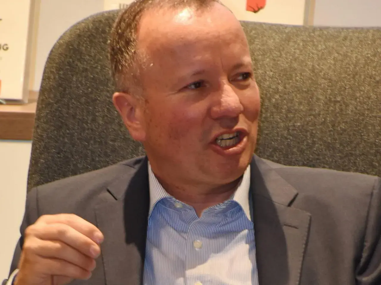 Markus Krall spricht lebhaft, vielleicht über seine Bücher. Er trägt einen Anzug und ein gestreiftes Hemd.