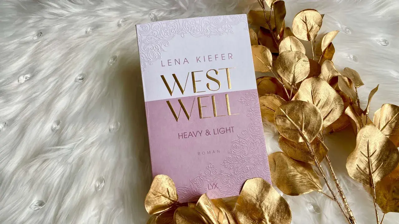 Lena Kiefer Roman "Westwell" auf flauschigem Untergrund, umrahmt von goldenen Blättern.