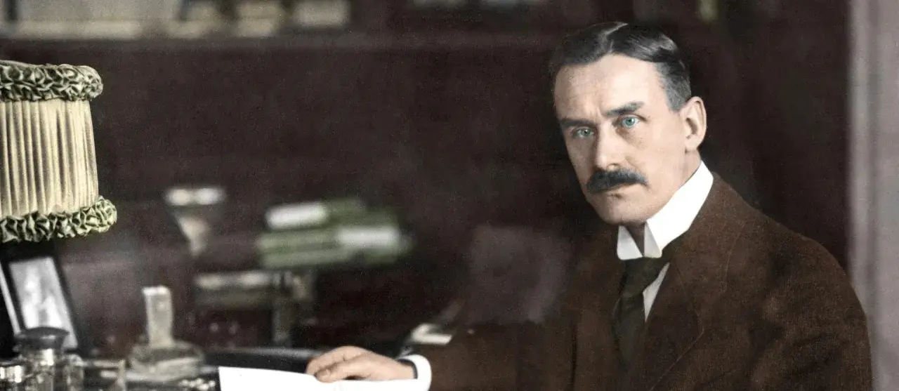 Ein Mann mit Schnurrbart und blauen Augen, der an seinem Schreibtisch sitzt. Er könnte ein Vorfahre in einem stammbaum familie mann sein.