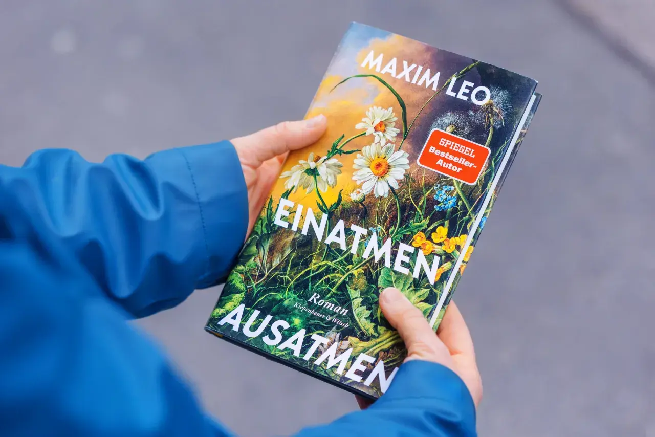 Hände halten das Buch "Einatmen Ausatmen" von SPIEGEL Bestseller-Autor Maxim Leo.