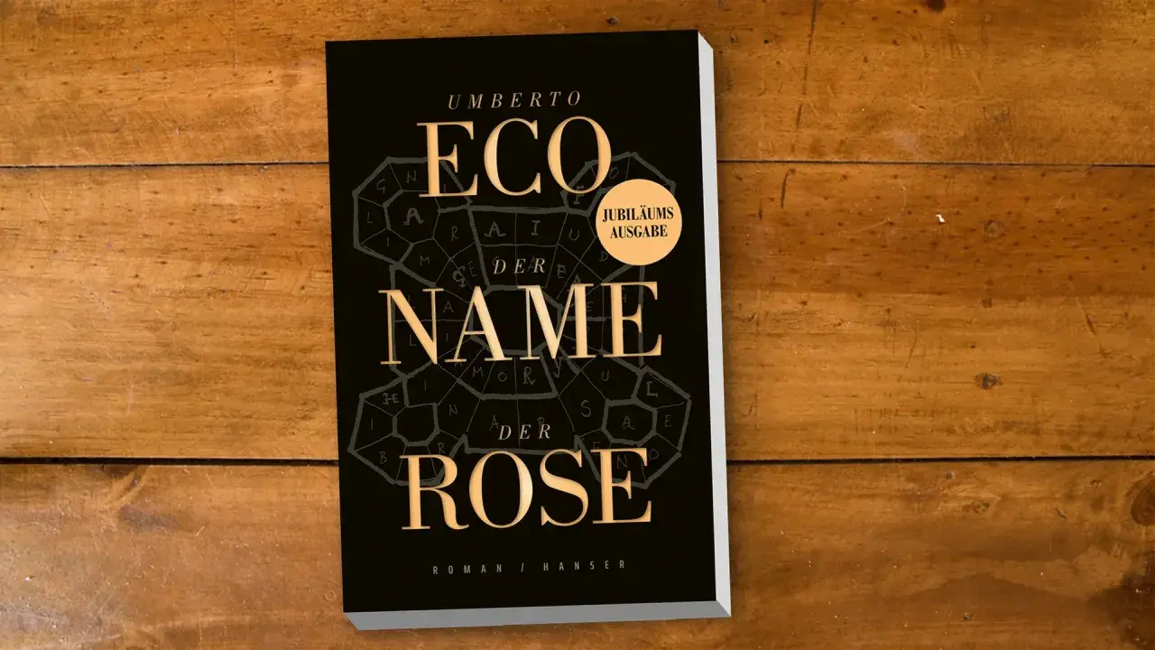 Umberto Ecos Roman "Im Namen der Rose" als Jubiläumsausgabe auf Holztisch.