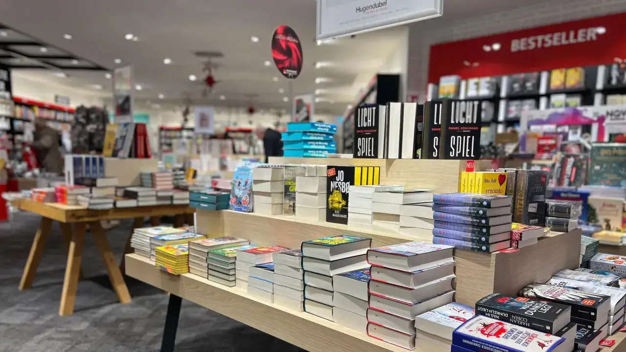B&uuml;cherregale voller Belletristik, darunter ein Stapel mit 